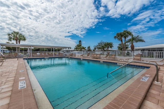 pool with fence and a patio