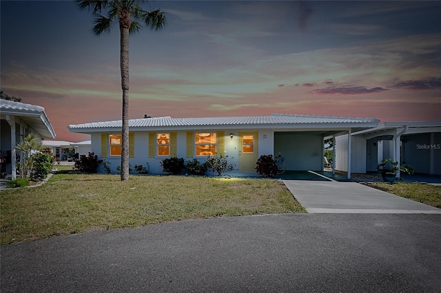 ranch-style home with concrete driveway, a front yard, and a carport