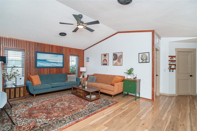 23 Tiffany St, Englewood, FL 34223 - living area with ceiling fan, light wood-type flooring, vaulted ceiling, baseboards, and a textured ceiling