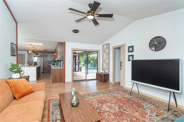 23 Tiffany St, Englewood, FL 34223 - living area with light wood-style floors, a ceiling fan, vaulted ceiling, and baseboards