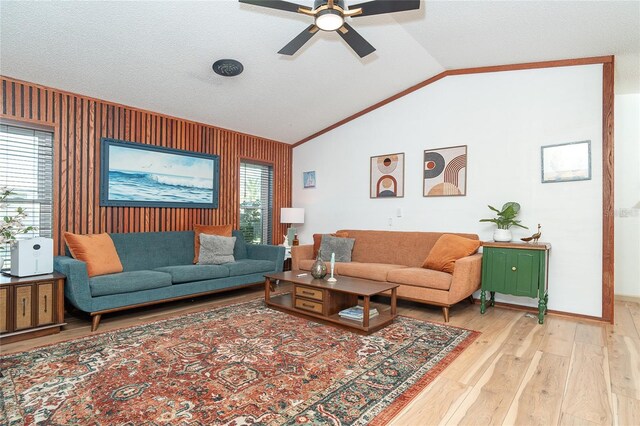 23 Tiffany St, Englewood, FL 34223 - living room featuring light wood-style flooring, lofted ceiling, ceiling fan, wood walls, and baseboards