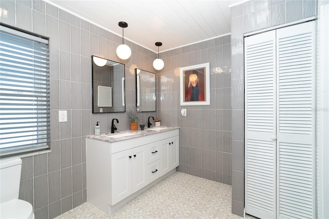 23 Tiffany St, Englewood, FL 34223 - full bath featuring tile walls, double vanity, toilet, a closet, and tile patterned flooring