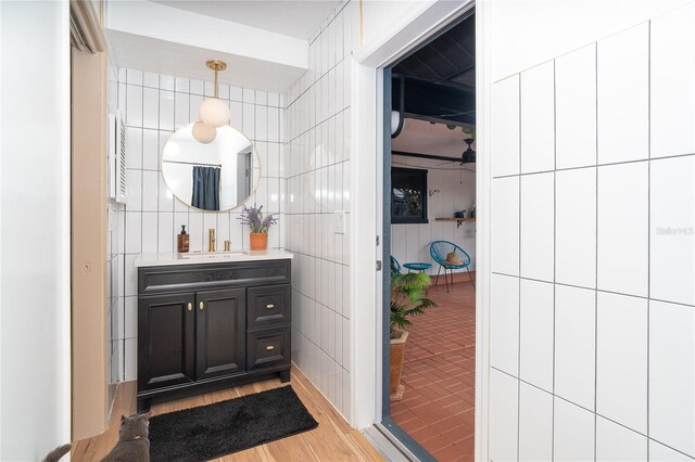 23 Tiffany St, Englewood, FL 34223 - bathroom with vanity, wood finished floors, and tile walls