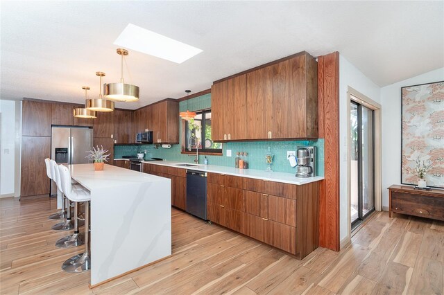 23 Tiffany St, Englewood, FL 34223 - kitchen featuring appliances with stainless steel finishes, a skylight, a breakfast bar area, tasteful backsplash, and lofted ceiling