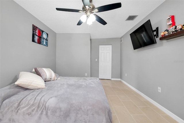 4068 Palau Dr, Sarasota, FL 34241 - bedroom with light tile patterned floors, a ceiling fan, and a closet