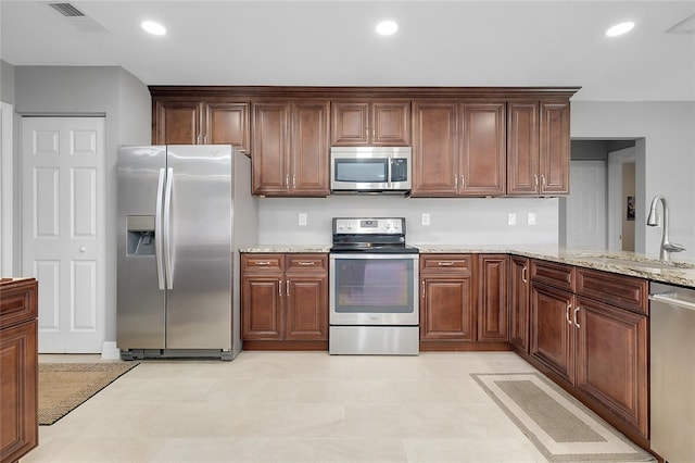 4068 Palau Dr, Sarasota, FL 34241 - kitchen with stainless steel appliances, recessed lighting, light stone counters, and light tile patterned floors