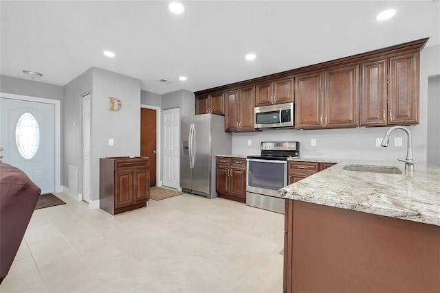 4068 Palau Dr, Sarasota, FL 34241 - kitchen featuring appliances with stainless steel finishes, light stone counters, and recessed lighting
