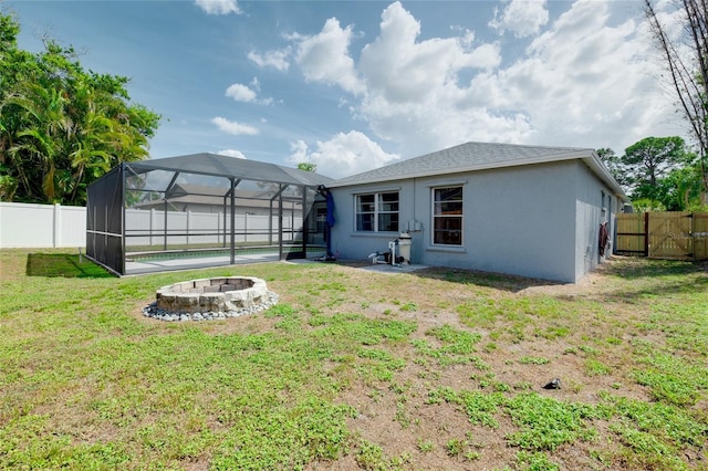 4068 Palau Dr, Sarasota, FL 34241 - back of property featuring a fire pit, a fenced backyard, stucco siding, and a lanai
