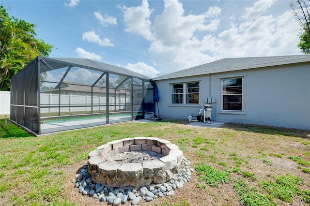4068 Palau Dr, Sarasota, FL 34241 - back of house with stucco siding, a fire pit, a lawn, and a lanai