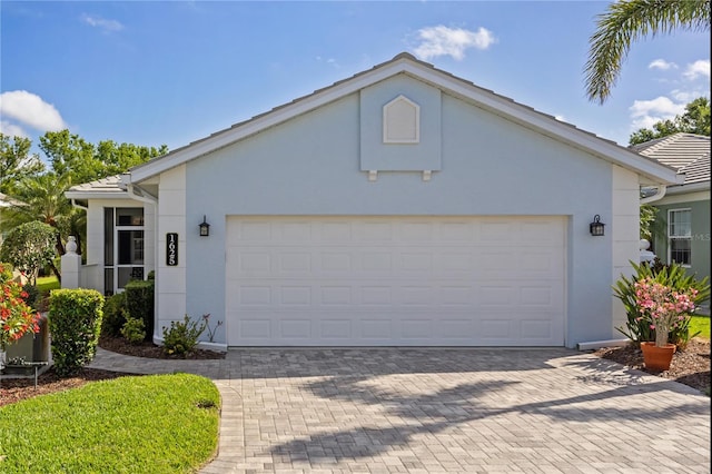 1625 Lancashire Dr, Venice, FL 34293 - view of front of home featuring an attached garage, decorative driveway, and stucco siding