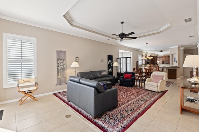 1625 Lancashire Dr, Venice, FL 34293 - living room with light tile patterned floors, ceiling fan with notable chandelier, crown molding, and a raised ceiling