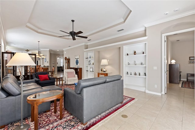 1625 Lancashire Dr, Venice, FL 34293 - living room with a tray ceiling, built in shelves, light tile patterned floors, and ceiling fan with notable chandelier