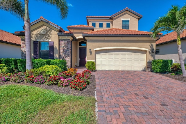 24193 Gallberry Dr, Venice, FL 34293 - mediterranean / spanish-style home featuring stucco siding, decorative driveway, an attached garage, and a tile roof