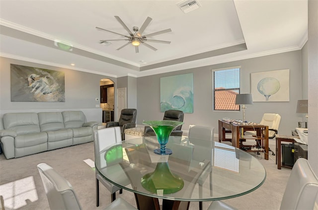 24193 Gallberry Dr, Venice, FL 34293 - dining space featuring a raised ceiling, crown molding, visible vents, ceiling fan, and arched walkways