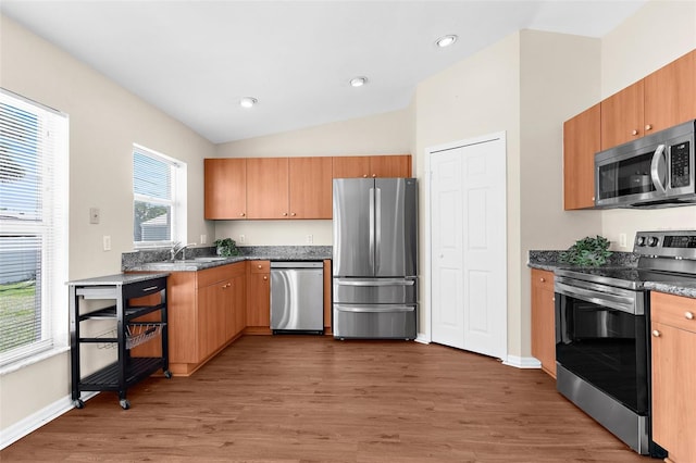 511 Porpoise Rd, Venice, FL 34293 - kitchen with vaulted ceiling, a sink, light wood-style floors, baseboards, and appliances with stainless steel finishes