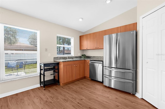 511 Porpoise Rd, Venice, FL 34293 - kitchen with lofted ceiling, stainless steel appliances, dark stone countertops, light wood-style floors, and baseboards