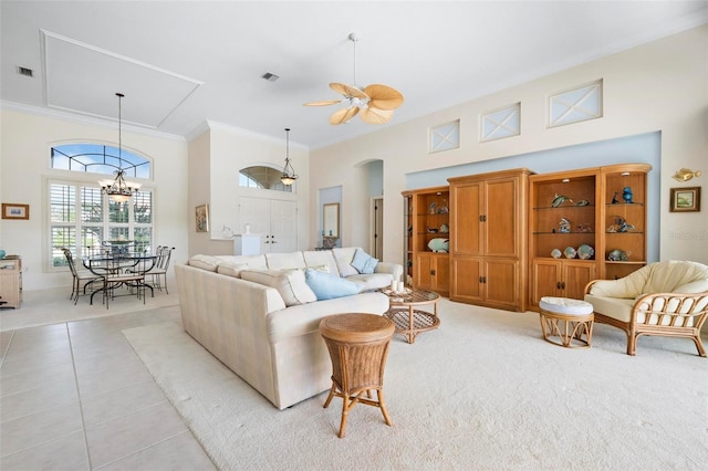living room with crown molding, light tile patterned floors, arched walkways, a towering ceiling, and visible vents