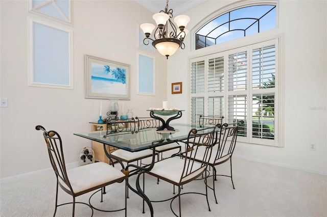 carpeted dining room with a chandelier and baseboards