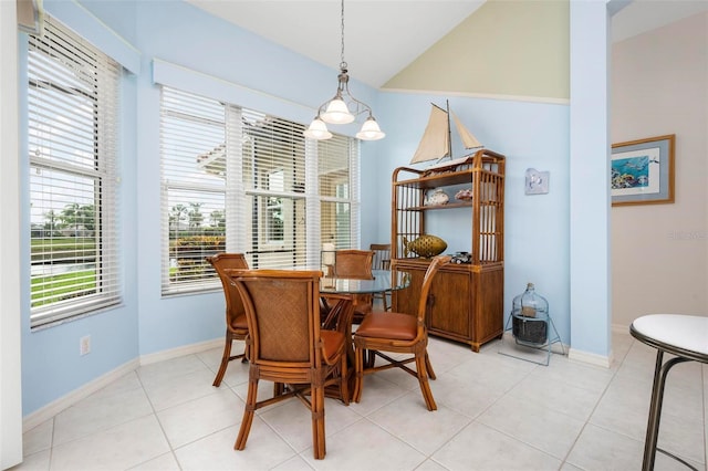 dining space featuring lofted ceiling, baseboards, and light tile patterned flooring