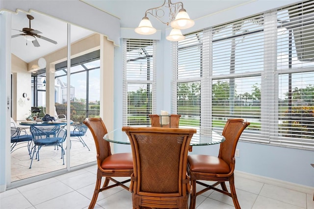 dining room featuring baseboards, light tile patterned flooring, and ceiling fan with notable chandelier