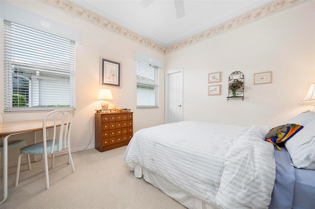 bedroom with ceiling fan, light colored carpet, and baseboards
