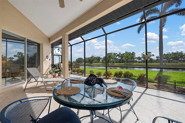 sunroom with ceiling fan, a wealth of natural light, and a water view