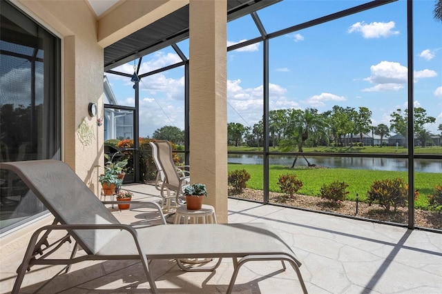 sunroom featuring a water view