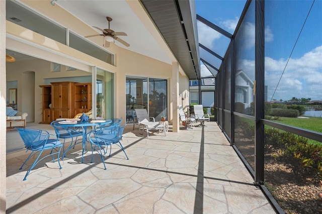 sunroom / solarium featuring arched walkways, visible vents, and a ceiling fan