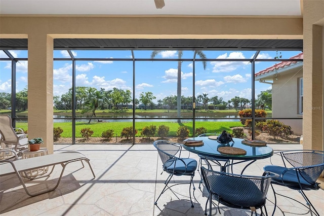 sunroom featuring stone finish floor, a wealth of natural light, and a water view