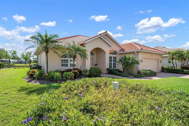 mediterranean / spanish-style house with a front yard, a tile roof, a garage, and stucco siding