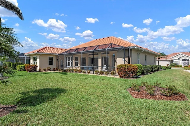rear view of house featuring a tiled roof, a lanai, a lawn, and stucco siding