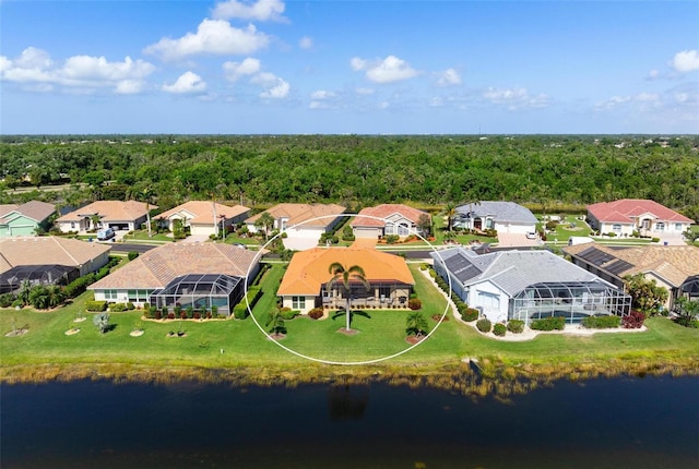 drone / aerial view with a water view, a residential view, and a forest view