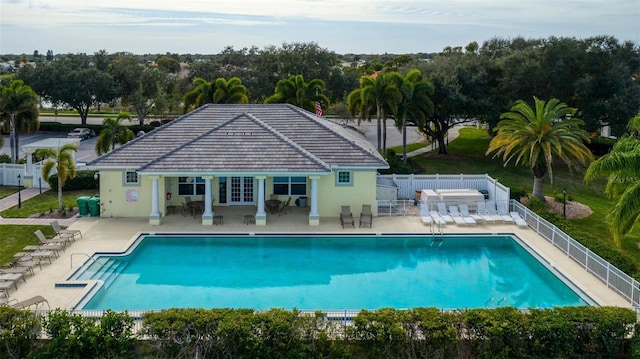 community pool featuring an outdoor structure, fence, a patio, and a storage structure