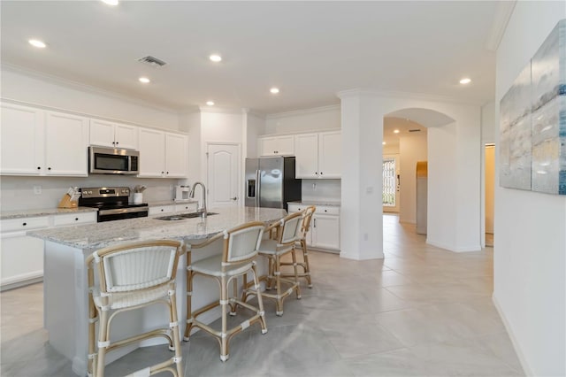 24153 Spartina Dr, Venice, FL 34293 - kitchen with visible vents, arched walkways, a sink, crown molding, and stainless steel appliances