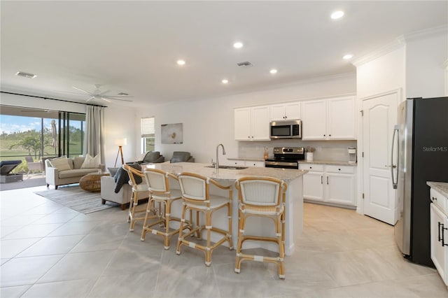 24153 Spartina Dr, Venice, FL 34293 - kitchen with stainless steel appliances, open floor plan, visible vents, and ornamental molding
