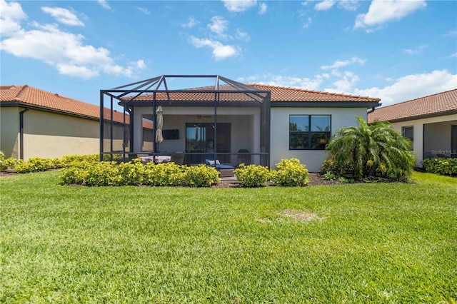 24153 Spartina Dr, Venice, FL 34293 - rear view of house featuring a yard, stucco siding, a tile roof, and glass enclosure