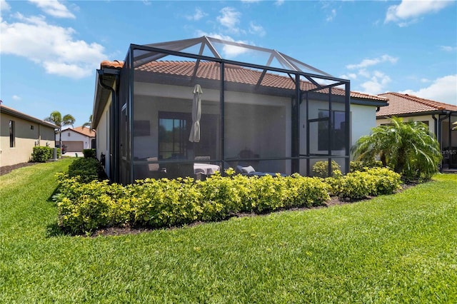 24153 Spartina Dr, Venice, FL 34293 - back of property with a yard, stucco siding, glass enclosure, and a tile roof