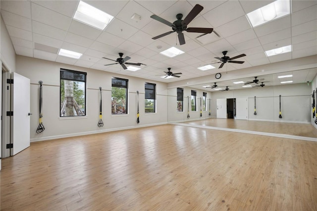 24153 Spartina Dr, Venice, FL 34293 - workout room featuring baseboards, a paneled ceiling, and light wood-style floors