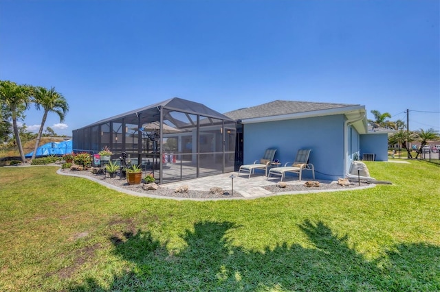 194 Sportsman Rd, Rotonda West, FL 33947 - back of property featuring stucco siding, a patio, glass enclosure, and a lawn