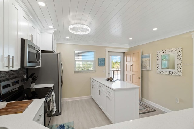 kitchen with stainless steel appliances, a peninsula, white cabinets, and light countertops