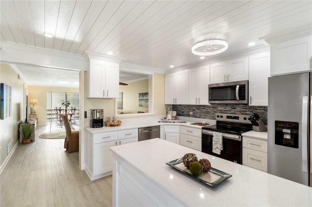 kitchen featuring light wood-style flooring, ornamental molding, white cabinets, appliances with stainless steel finishes, and backsplash