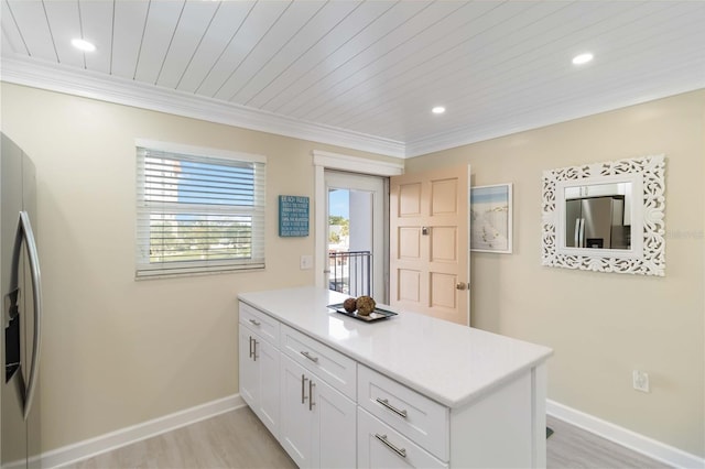 kitchen featuring baseboards, light countertops, white cabinets, and stainless steel refrigerator with ice dispenser