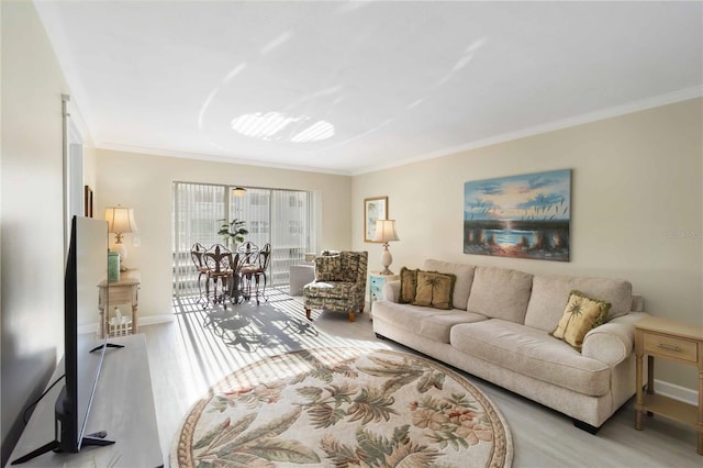 living area featuring light wood-style floors, crown molding, and baseboards