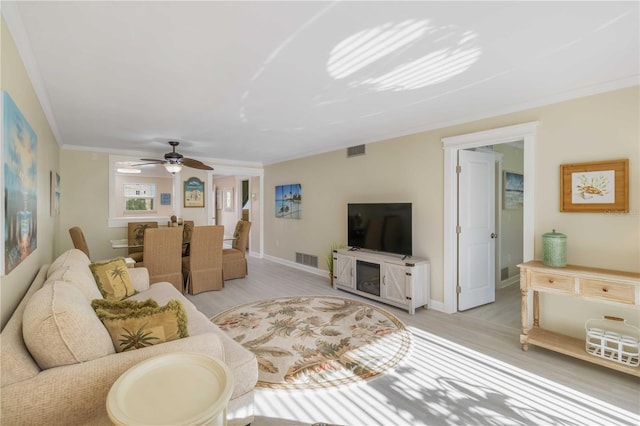 living room featuring light wood-style flooring, ceiling fan, and visible vents