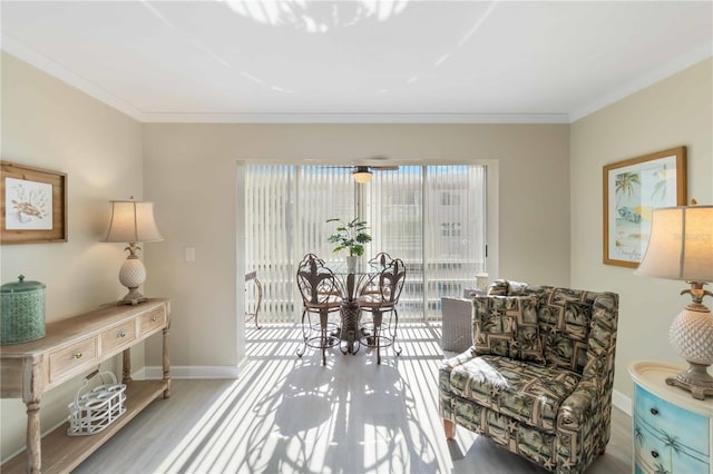 living area with ornamental molding, baseboards, and wood finished floors