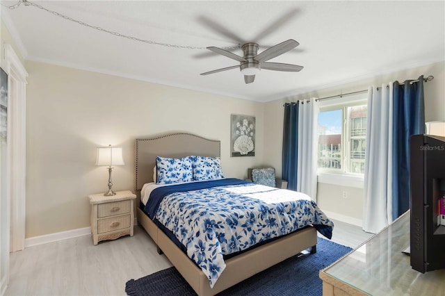 bedroom featuring light wood-type flooring, baseboards, and crown molding