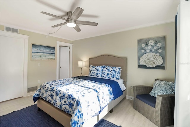 bedroom featuring visible vents, a ceiling fan, and wood finished floors