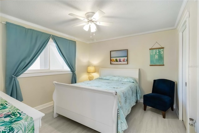 bedroom with light wood-style floors, ceiling fan, baseboards, and ornamental molding