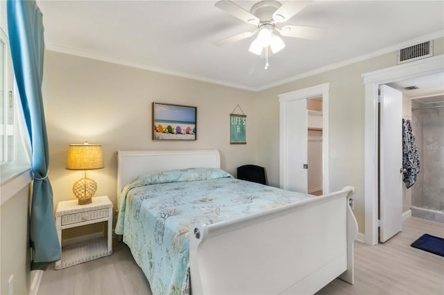 bedroom with crown molding, wood finished floors, baseboards, and visible vents