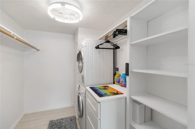 230 Santa Maria St Unit 333, Venice, FL 34285 - laundry area with stacked washer / drying machine, light wood-type flooring, a textured ceiling, and baseboards